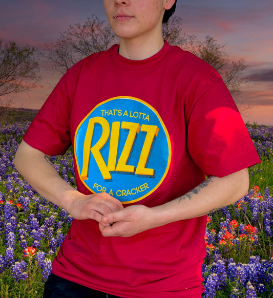 Person wearing a red t-shirt with 'Rizz' graphic in a field of flowers